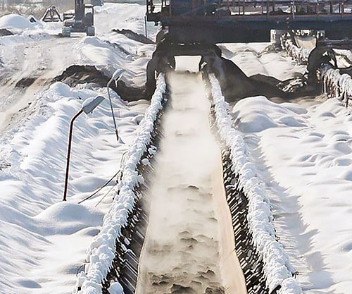 heavy stones being carried on Cold resistant conveyor belt. in hard cold snow Environment