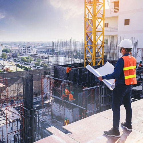 construction engineer watching workers work on a construction project